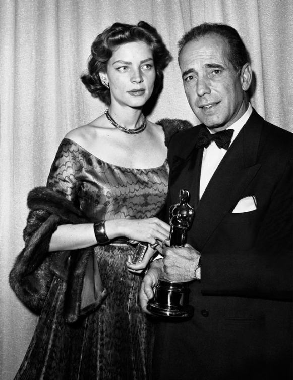 LOS ANGELES - MARCH 20: Married actors Humphrey Bogart and Lauren Bacall pose for a portrait at the Academy Awards ceremony which was held at the RKO Pantages Theater on March 20, 1952 in Los Angeles, California. Bogart holds the Oscar he won for best actor in John Huston's film "The Afircan Queen." (Photo by Frank Worth, Courtesy of Emage International/Getty Images)
